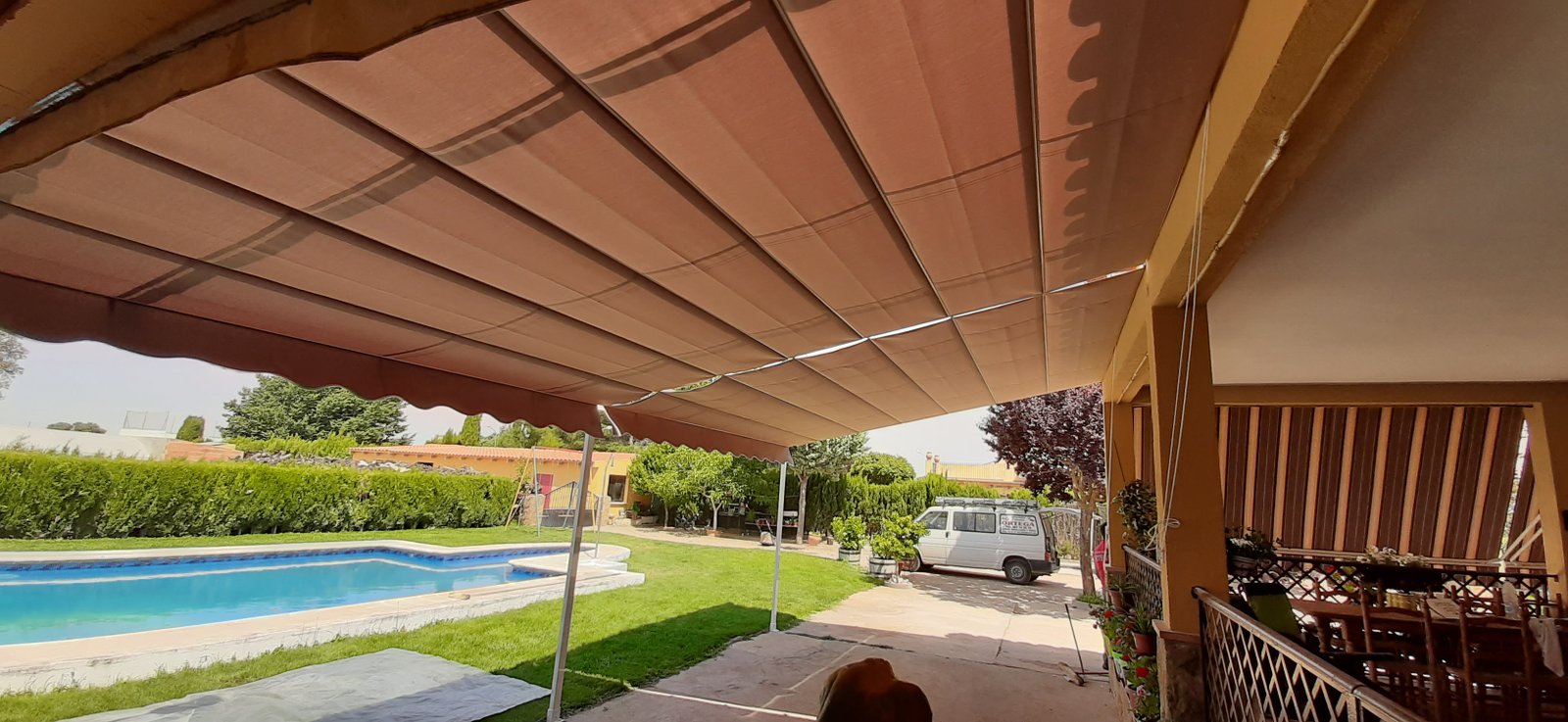 Toldo extensible junto a piscina